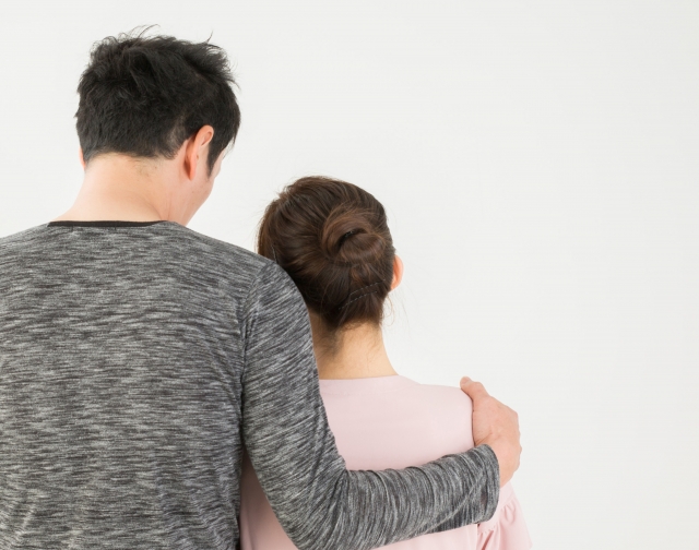 女性の肩を抱く男性