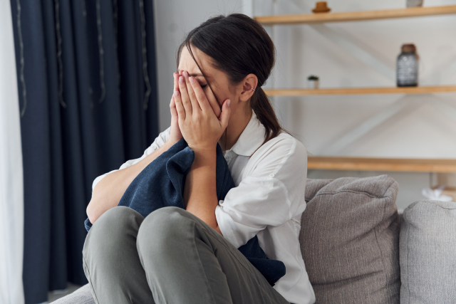 両手で顔を押さえて泣いている女性