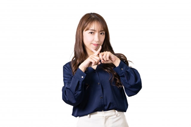 バツのポーズをする女性