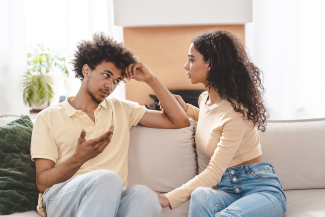 困った顔の男性を見る女性