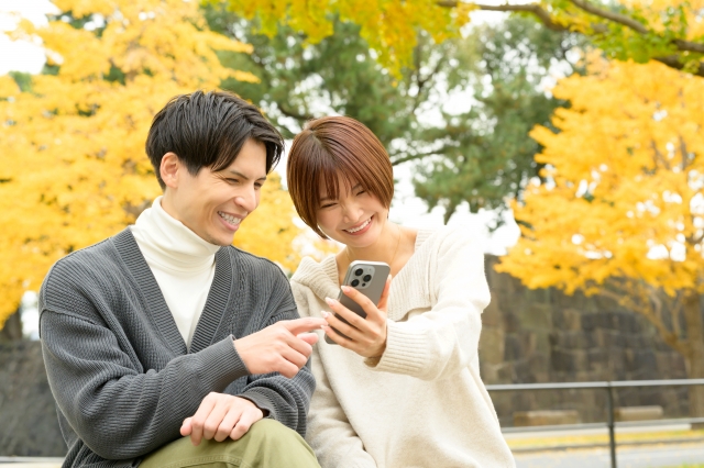 公園でスマホを見る男女