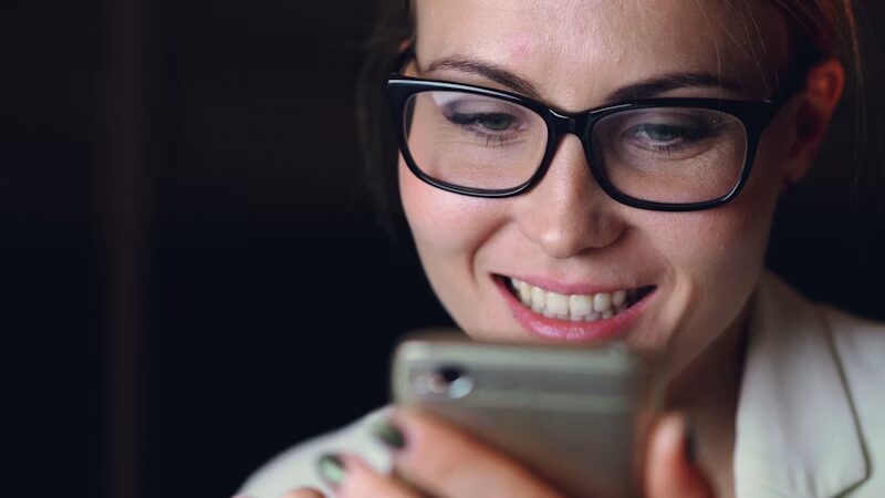 スマホを見てほほえむ女性