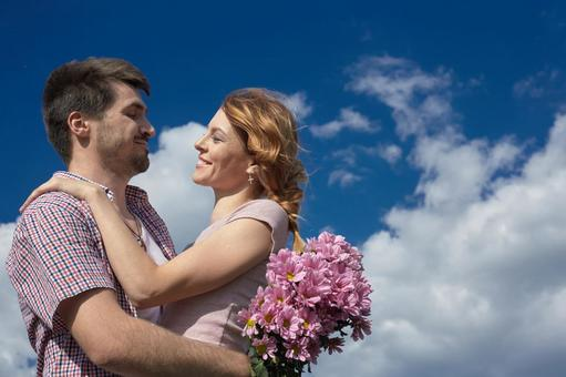 青空の下抱き合うカップル